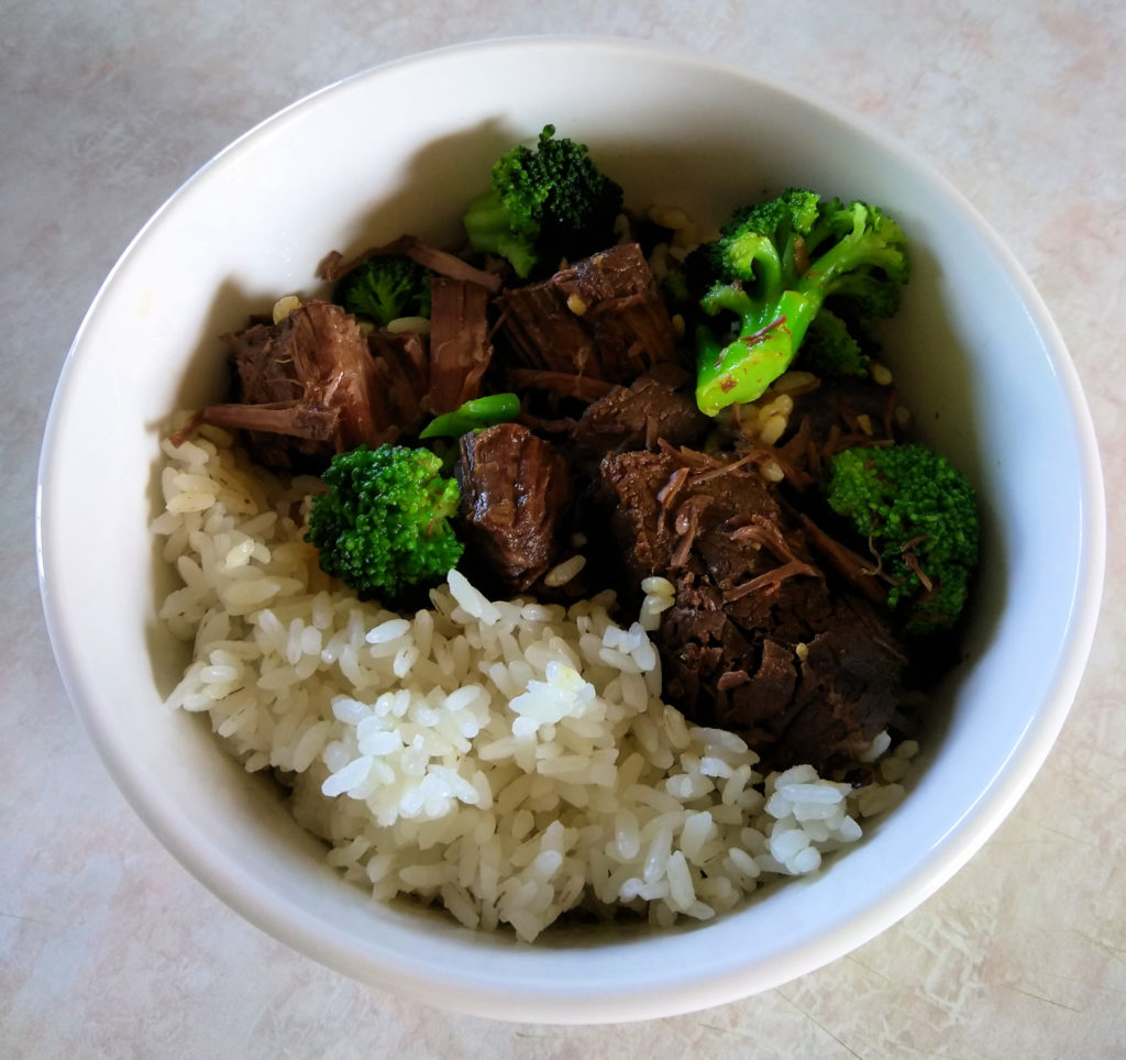 White bowl filled with beef, broccoli, and rice.