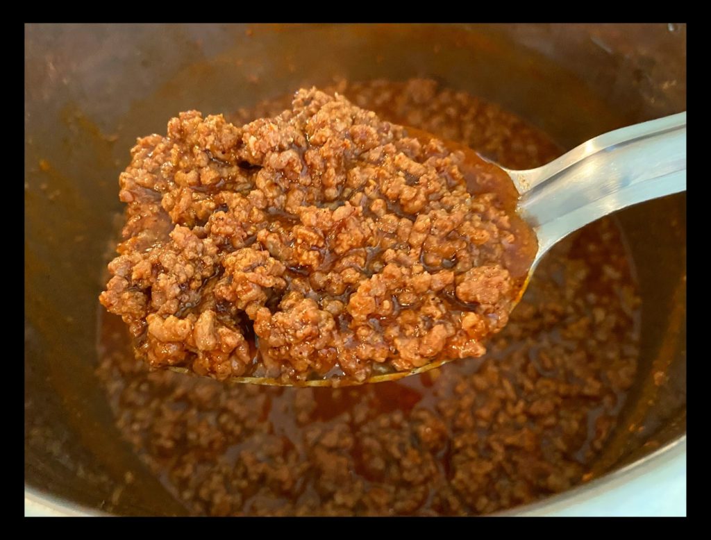 An Instant Pot filled with no bean chili and a big spoonfull of no bean chili.