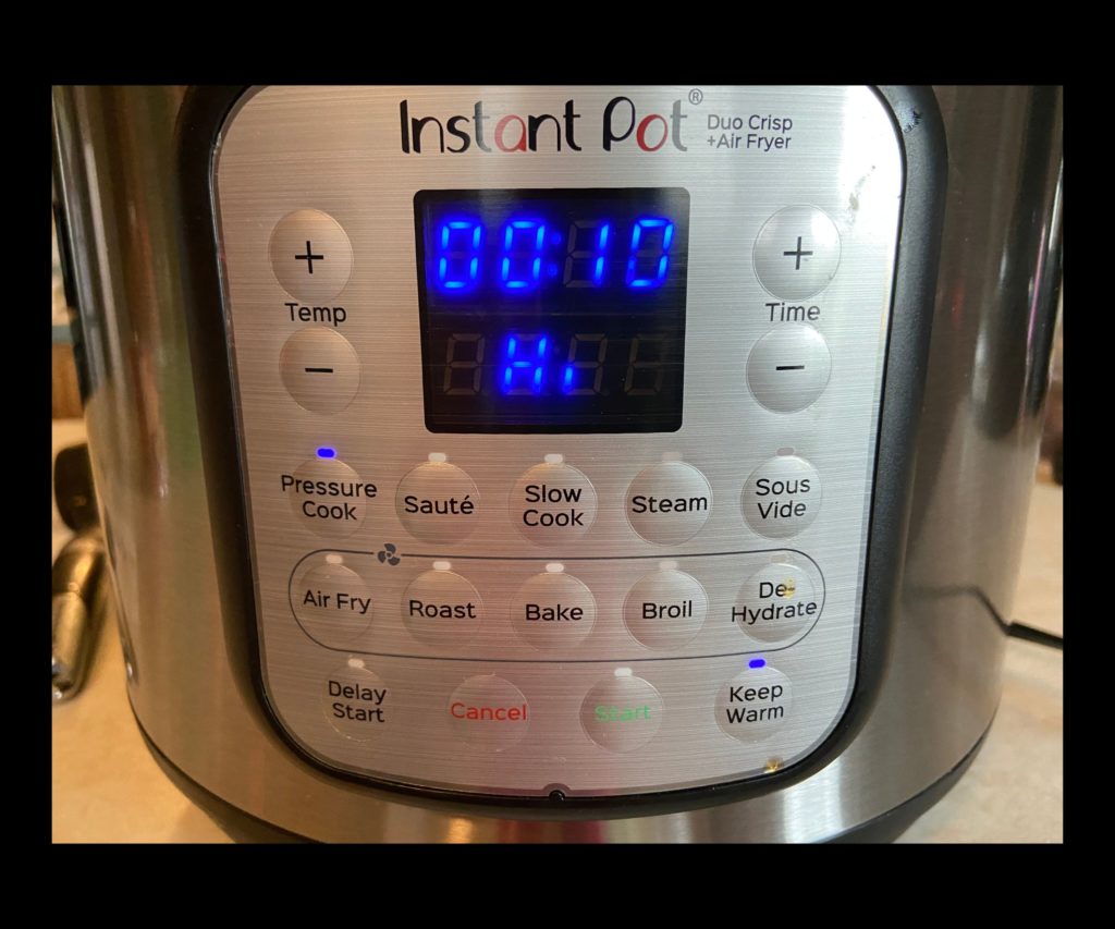The front of an Instant pot duo crisp displaying Hi pressure at 10 minutes selected.
