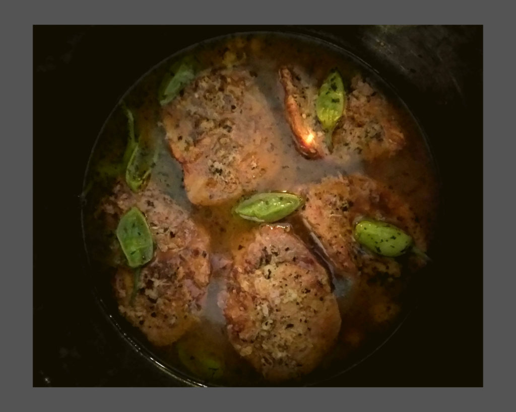 A silver instant pot filled with mississippi pork roast cooked with green peppers on top.