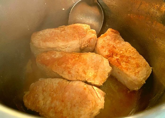 Pork chops inside of an Instant Pot cooking Instant Pot Mississippi Pork Roast.