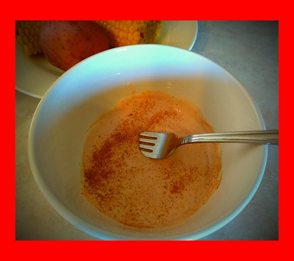 A white bowl filled with cajun shrimp boil sauce.