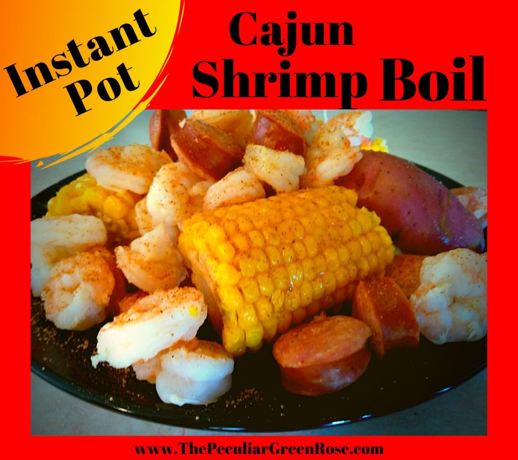 A black plate filled with boiled shrimp, corn, and potatoes covered in melted butter and tony chachere's seasoning.