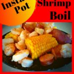 A black plate with boiled shrimp, corn, potatoes, and sausage drizzled with melted butter and tony chachere's.
