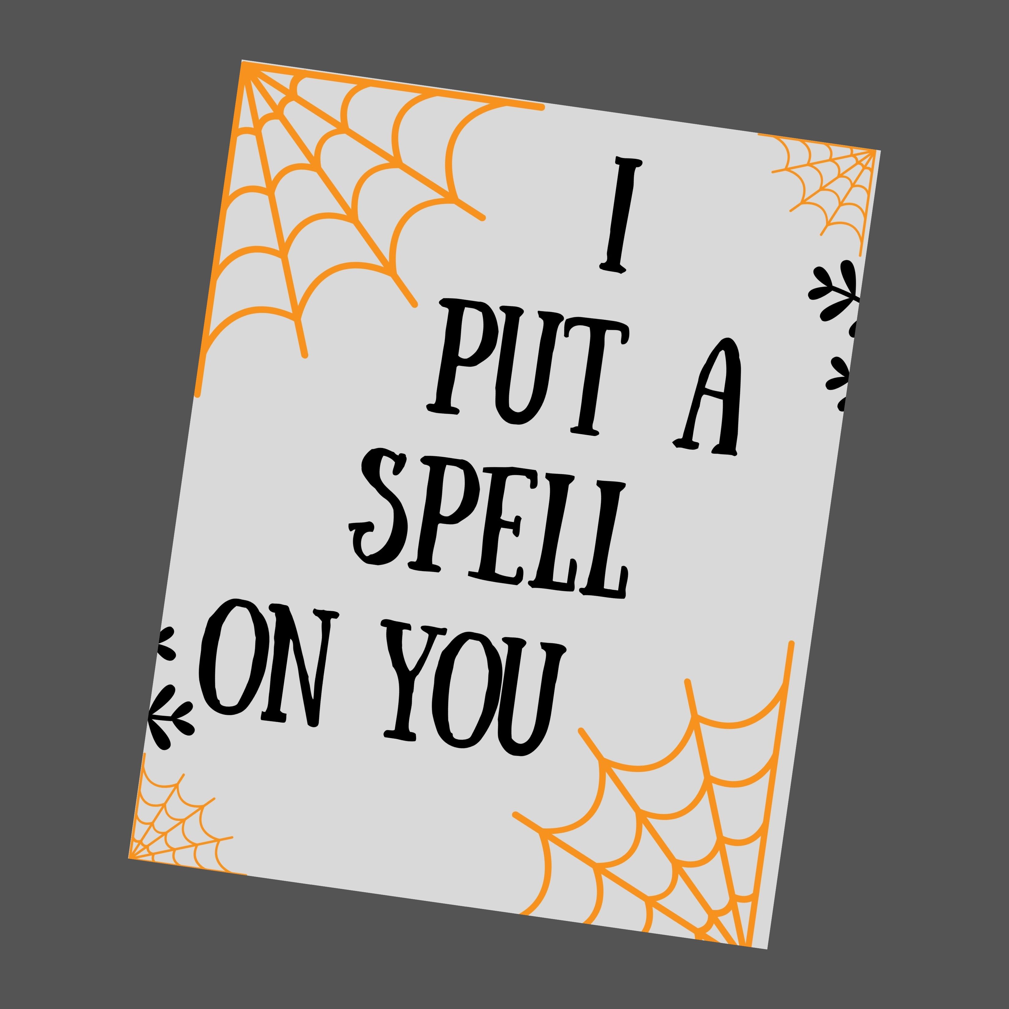 A grey halloween printable with yellow spider webs that says " I put a spell on you".