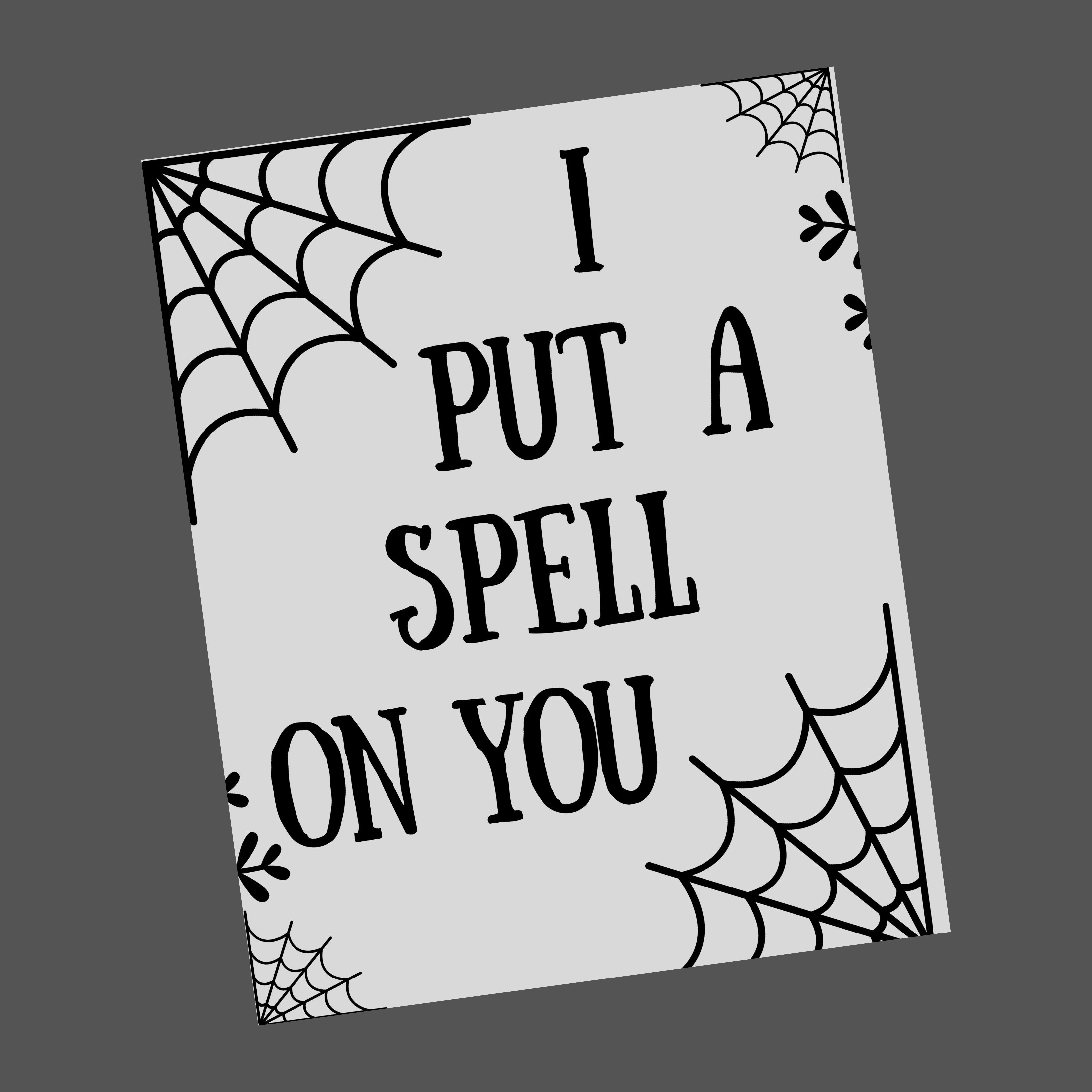 A black and white halloween printable with spider webs and says "I put a spell on you"