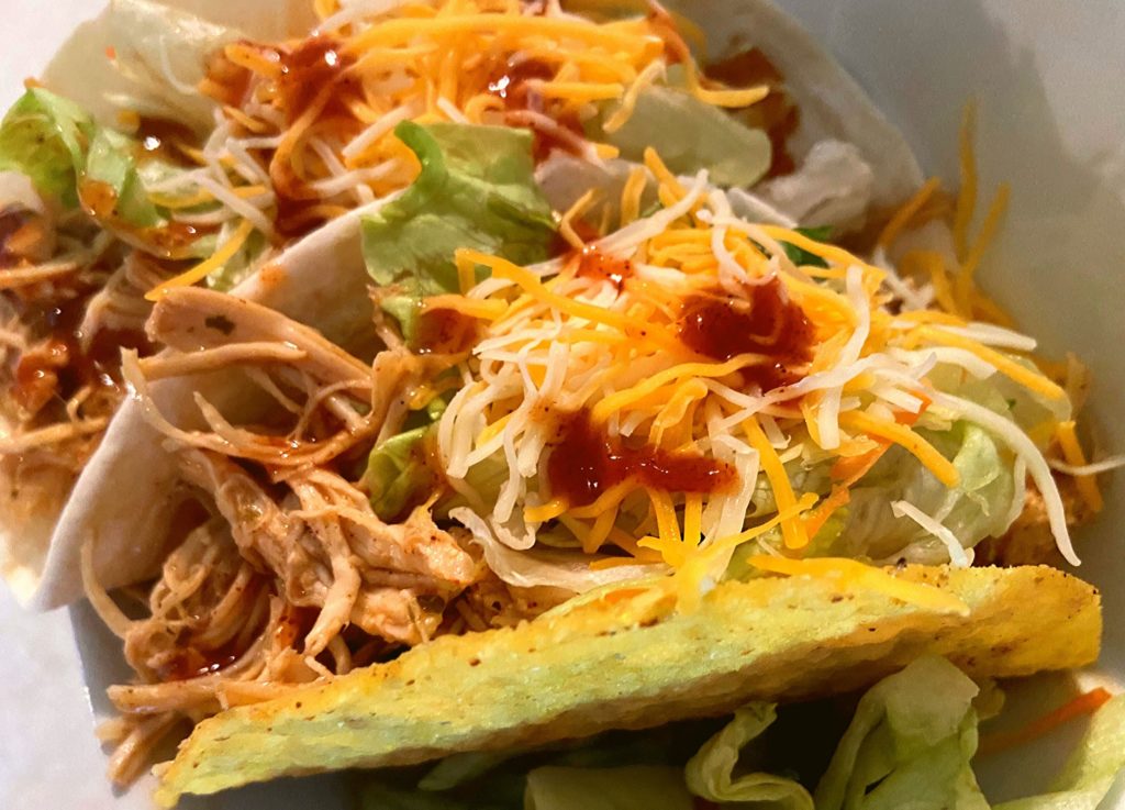 A hard and soft shell Instant Pot Shredded Ranch Chicken Tacos.