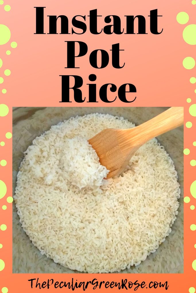 A silver instant pot with cooked white rice inside and a wooden spoon.