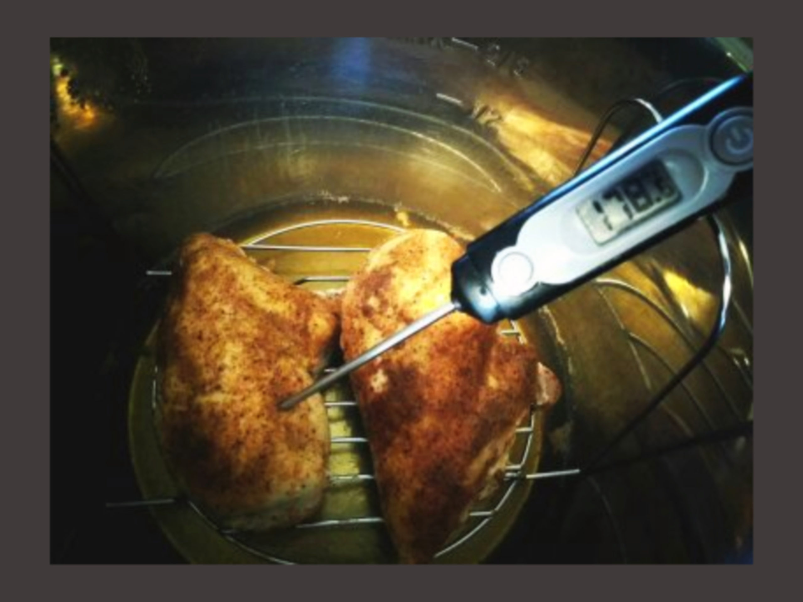 The inside of an Instant Pot with 2 Cooked Chicken Breasts with a digital thermometer.