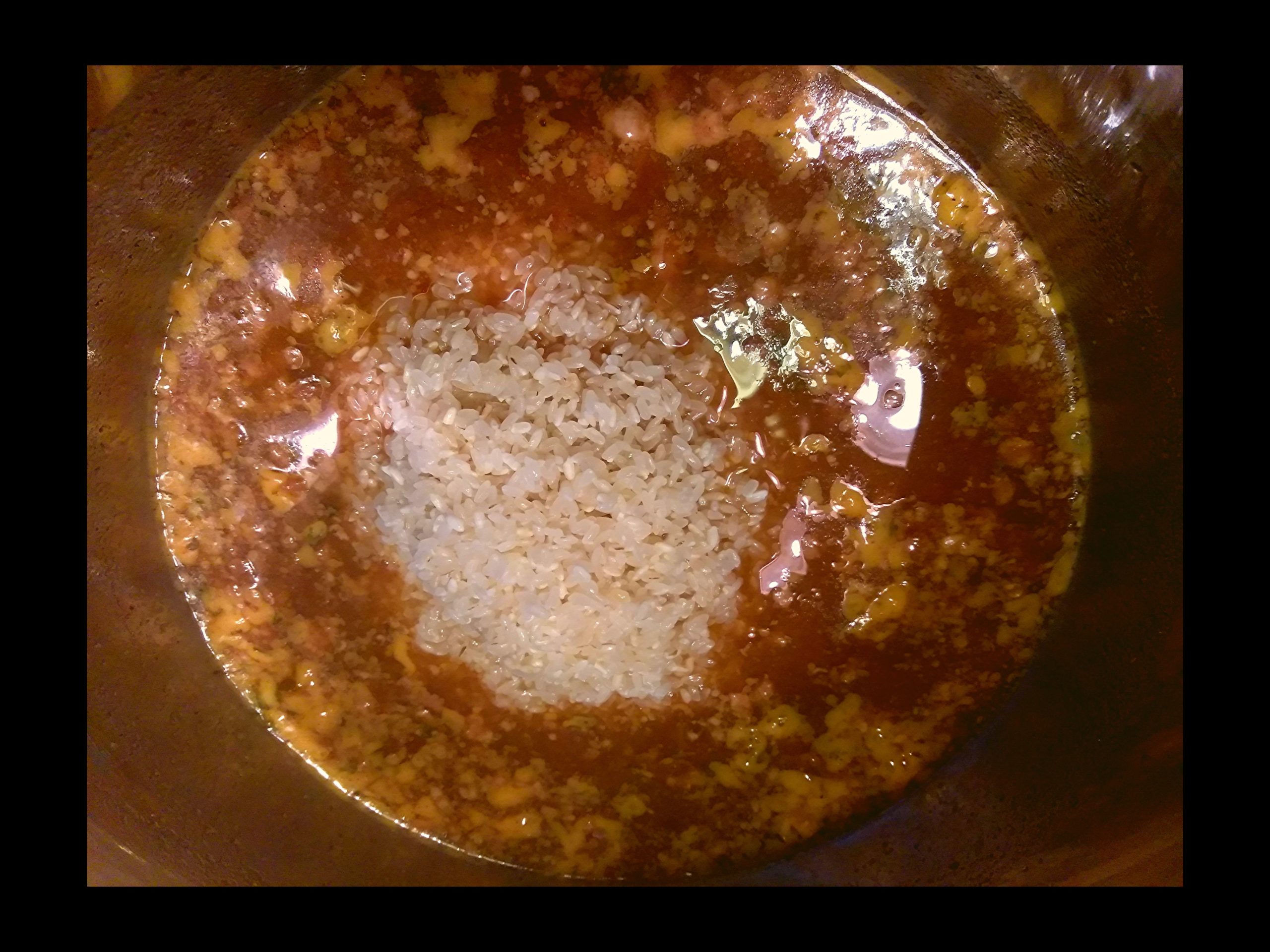 The inside of an Instant Pot with Savoies Cajun Dressing Mix and a pile up uncooked medium grain white rice