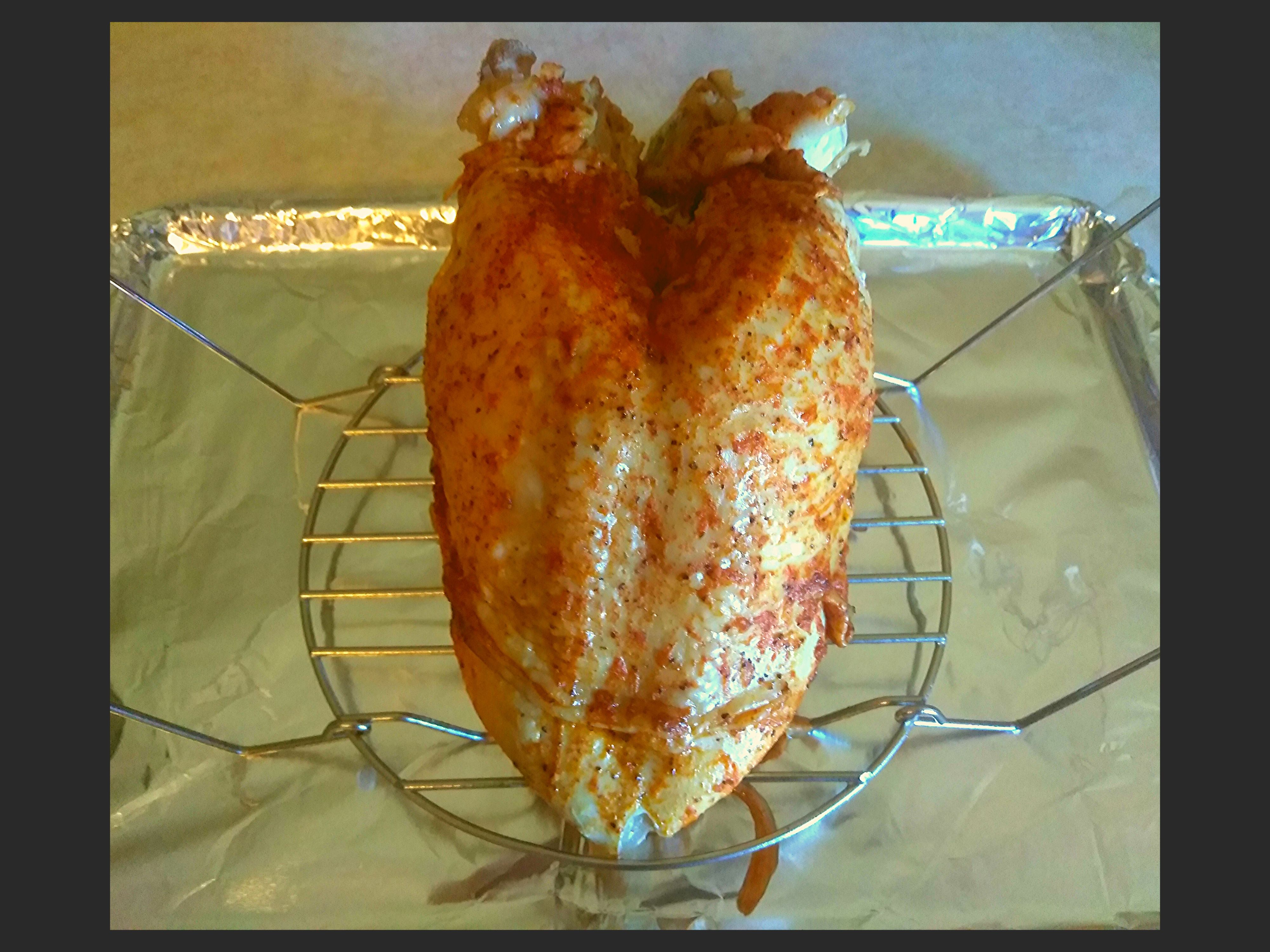 Turkey breast after pressure cooking still sitting on a trivet but placed on an aluminum pan.
