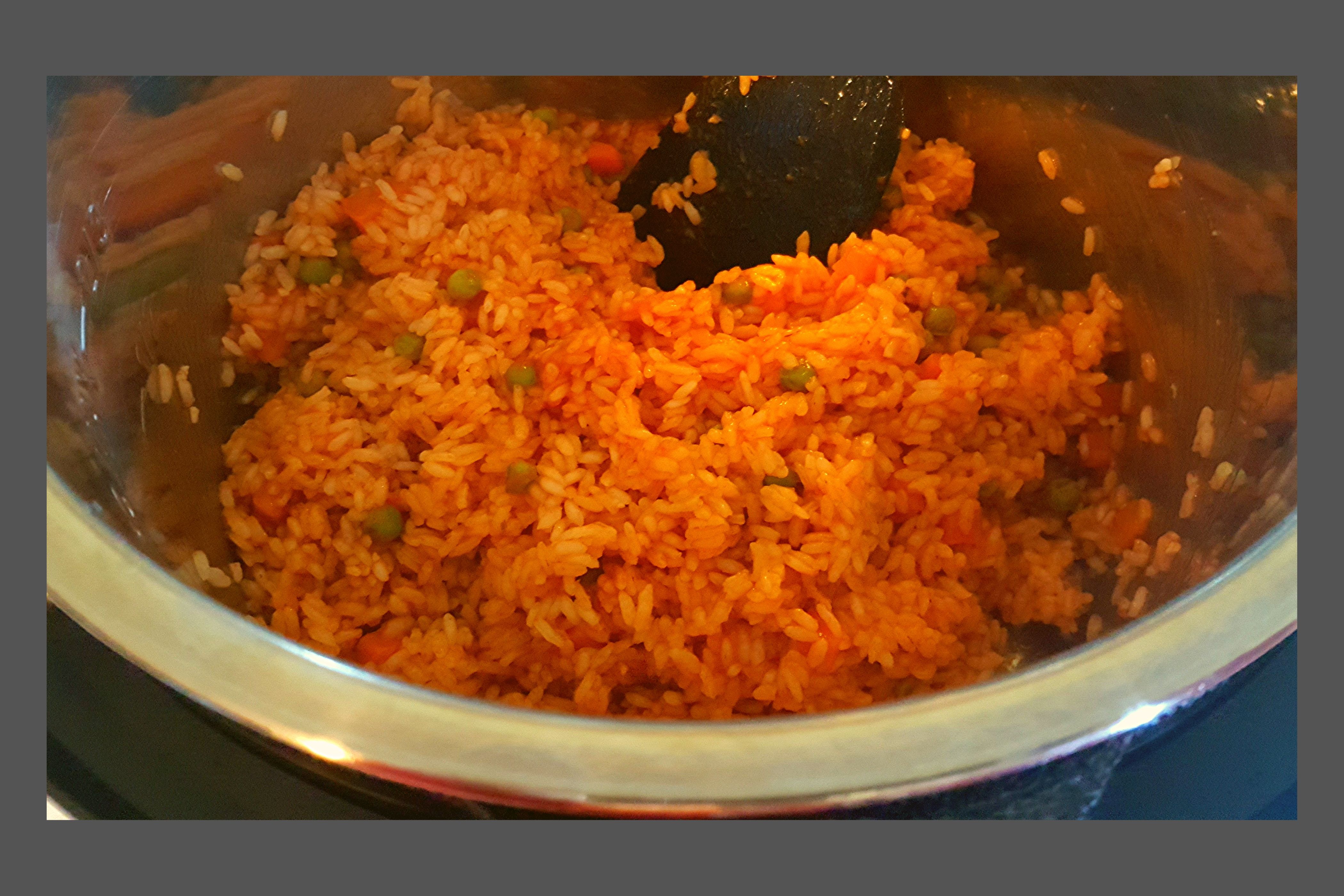 A silver Instant Pot filled with Mexican Rice with peas and carrots.