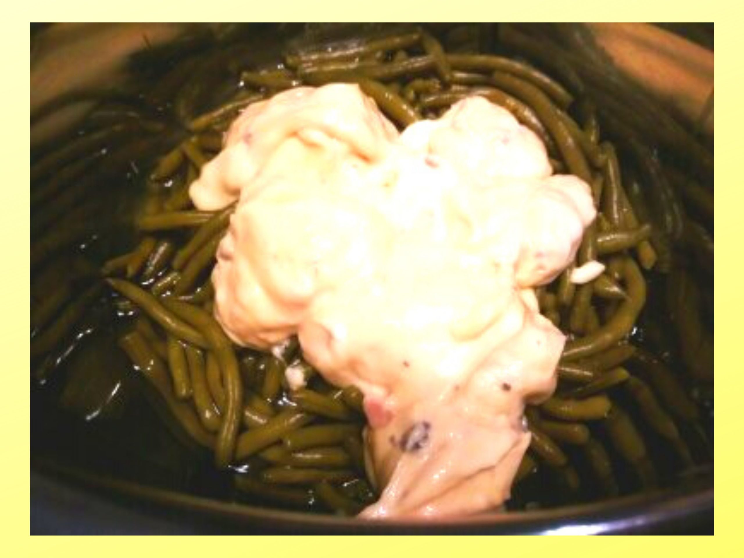 The inside of an Instant Pot filled with whole green beans, chicken broth, and cream of mushroom with cream of chicken.