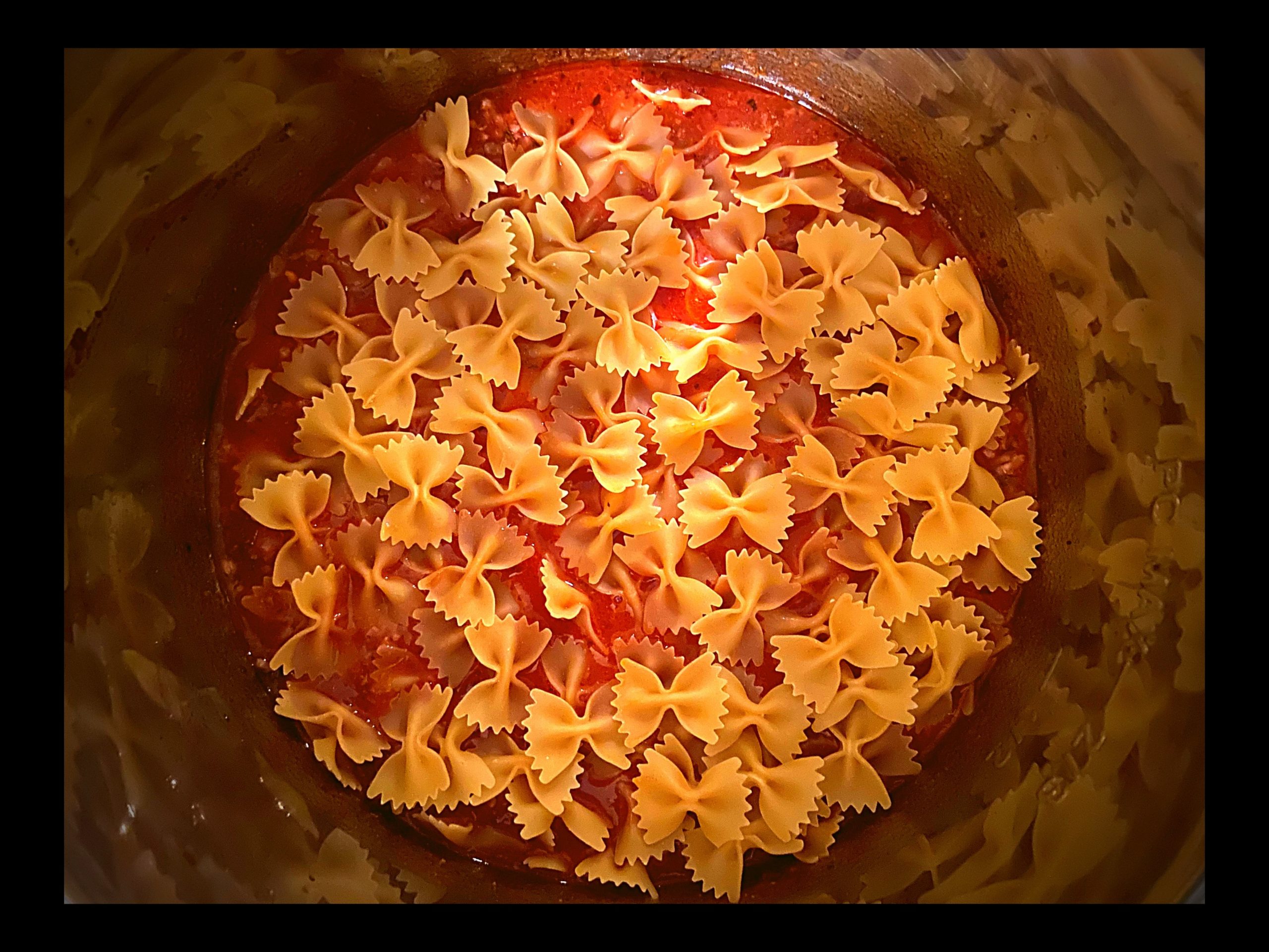 An Instant Pot filled with bow tie pasta in ragu spaghetti sauce