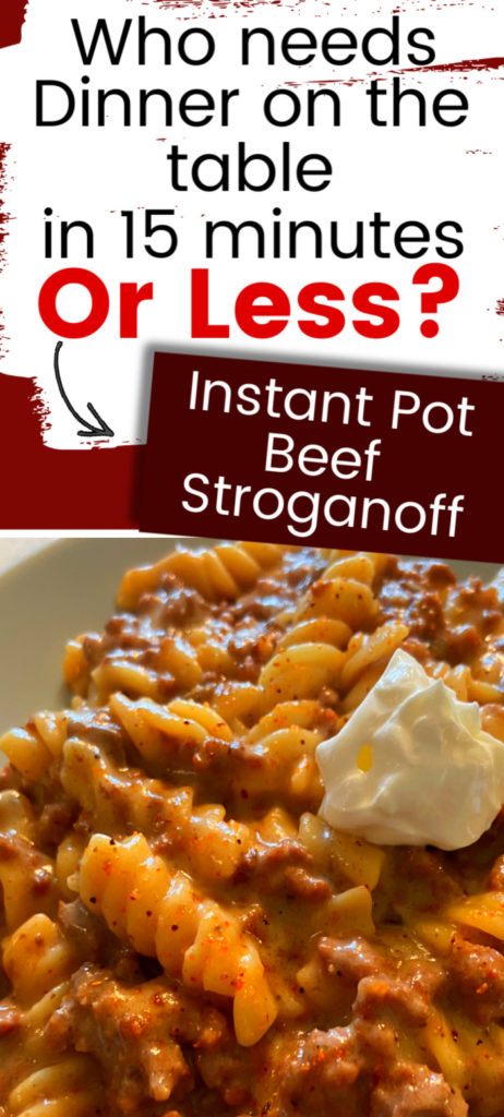 A grey plate filled with ground beef stroganoff topped with a spoonfull of sour cream.