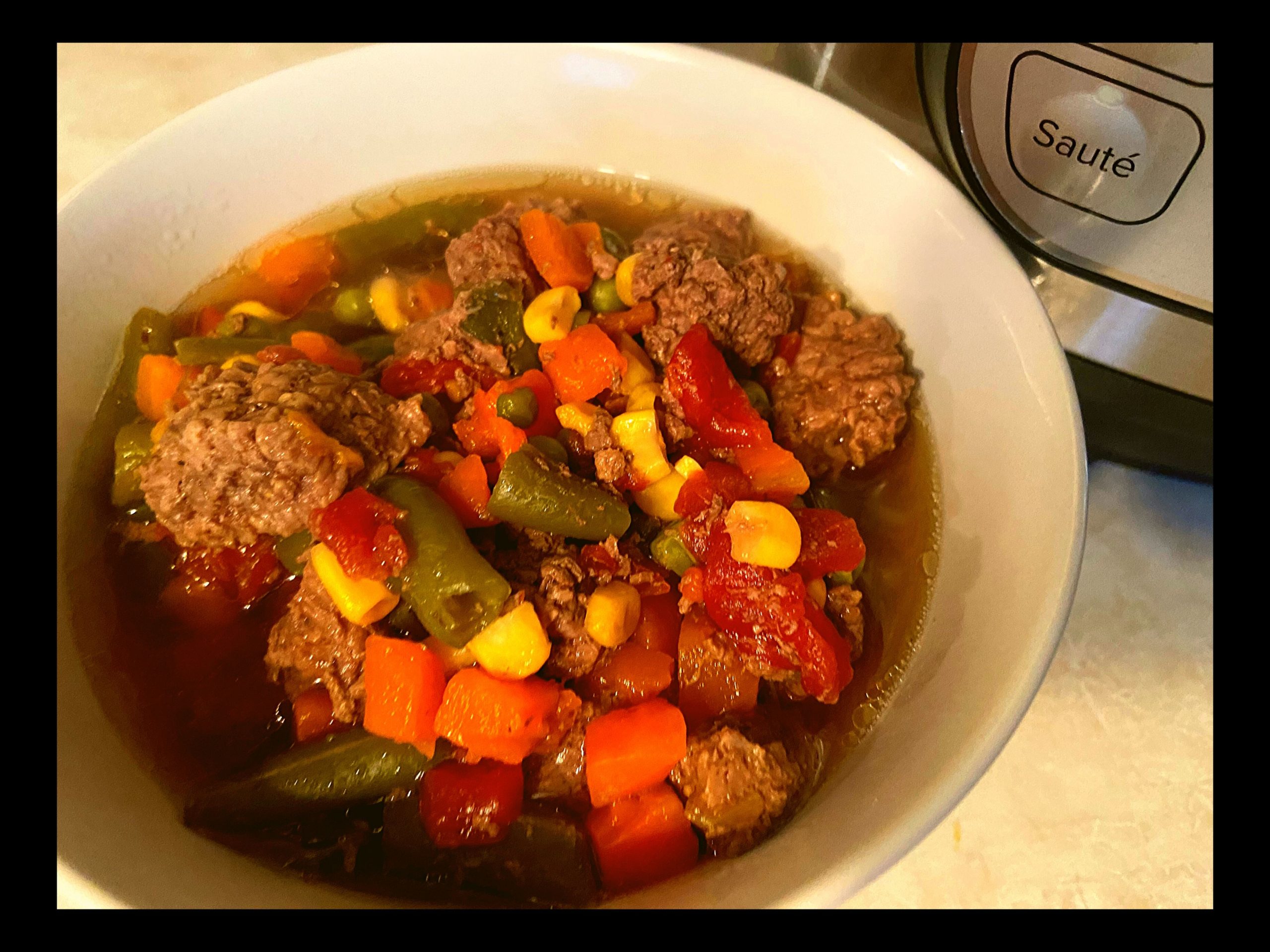 A white round bowl filled with Instant Pot Beef Vegetable Soup.