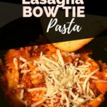 Instant pot bow tie lasagna in a black bowl topped with shredded mozzarella cheese and a garlic bread.