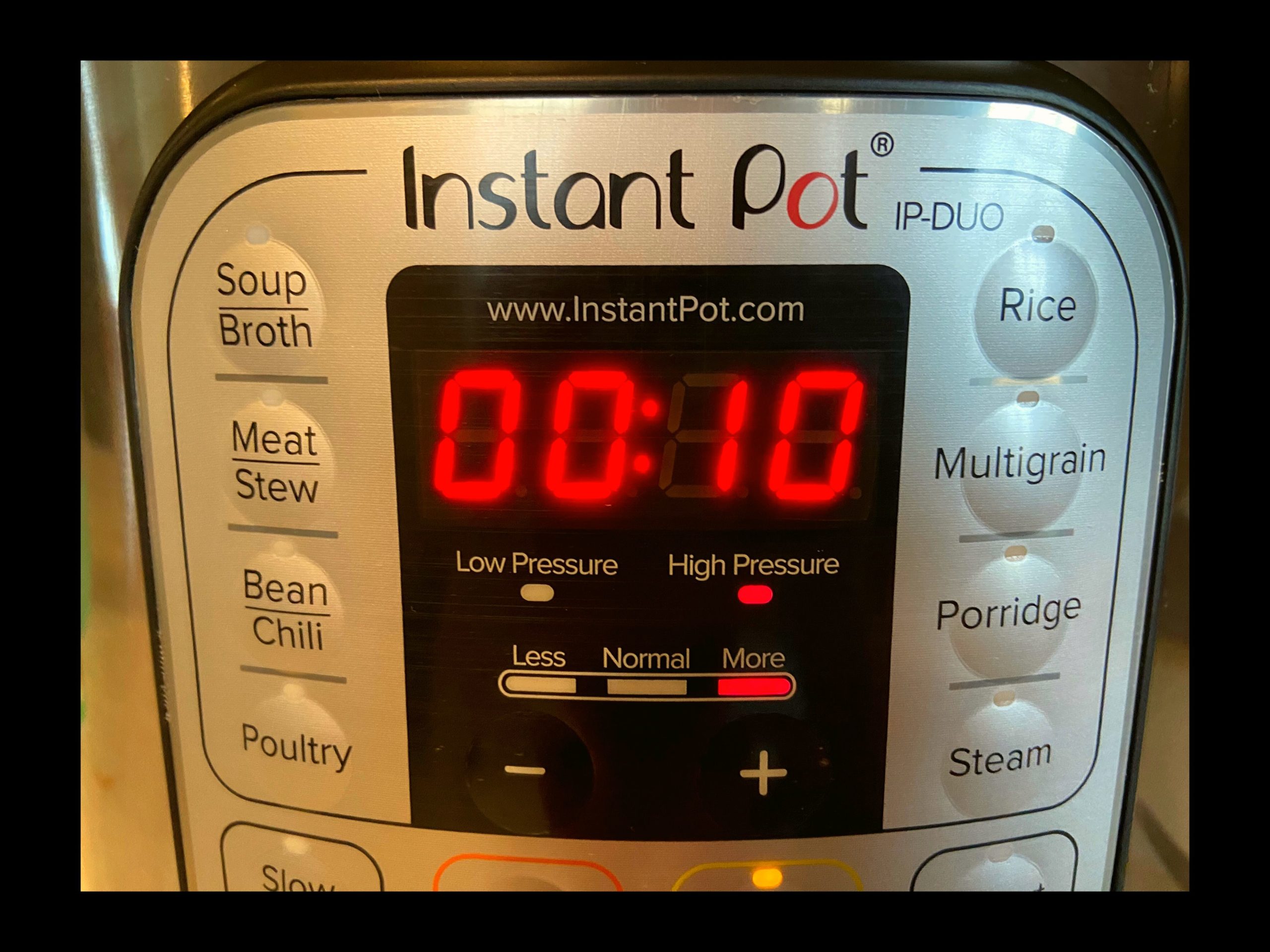 The timer on the front of an 8 qt. Instant Pot displaying 10 minutes of High Pressure selected.