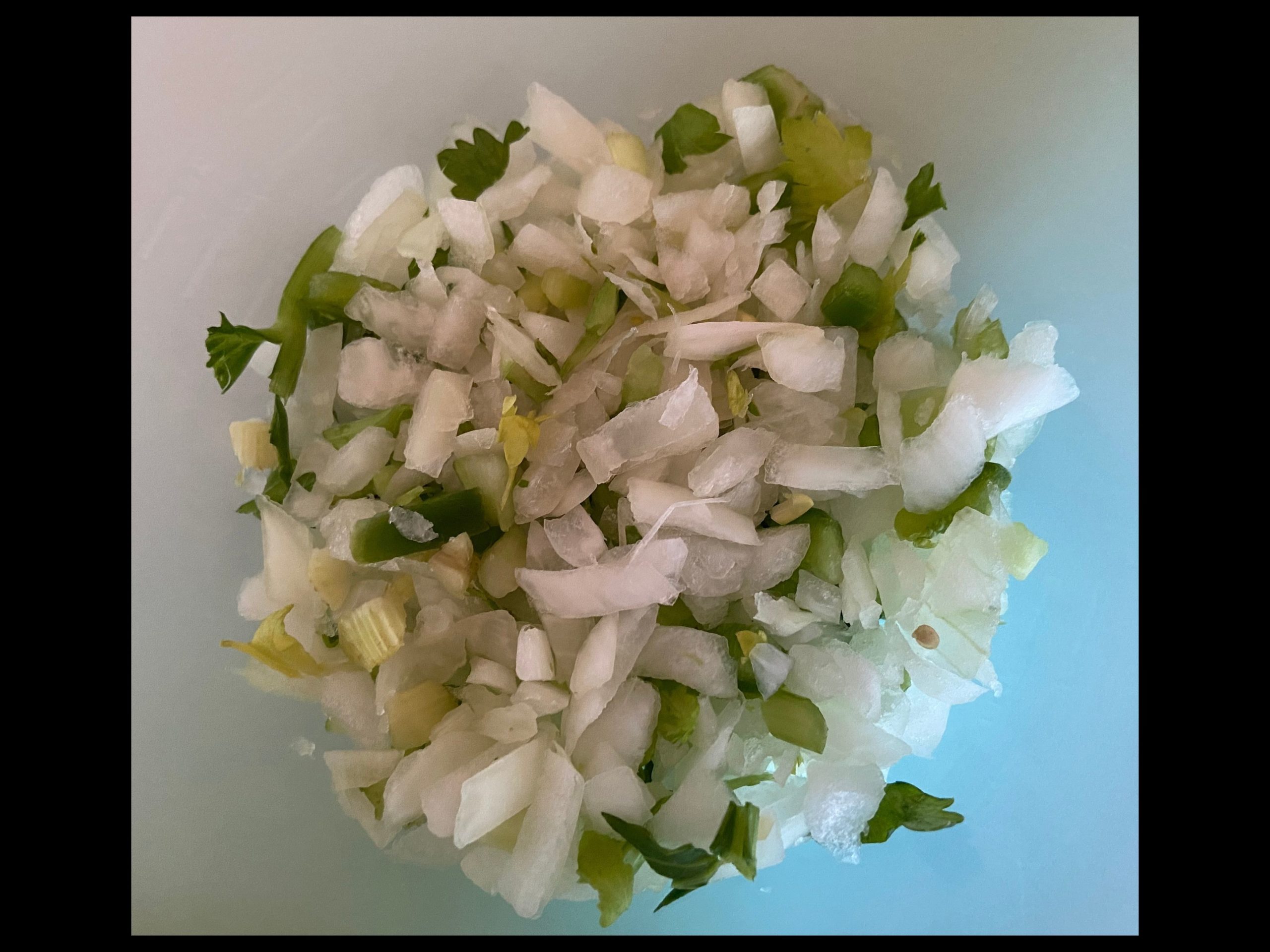 Holy Trinity - diced onions, bell peppers, and celery on a cutting board