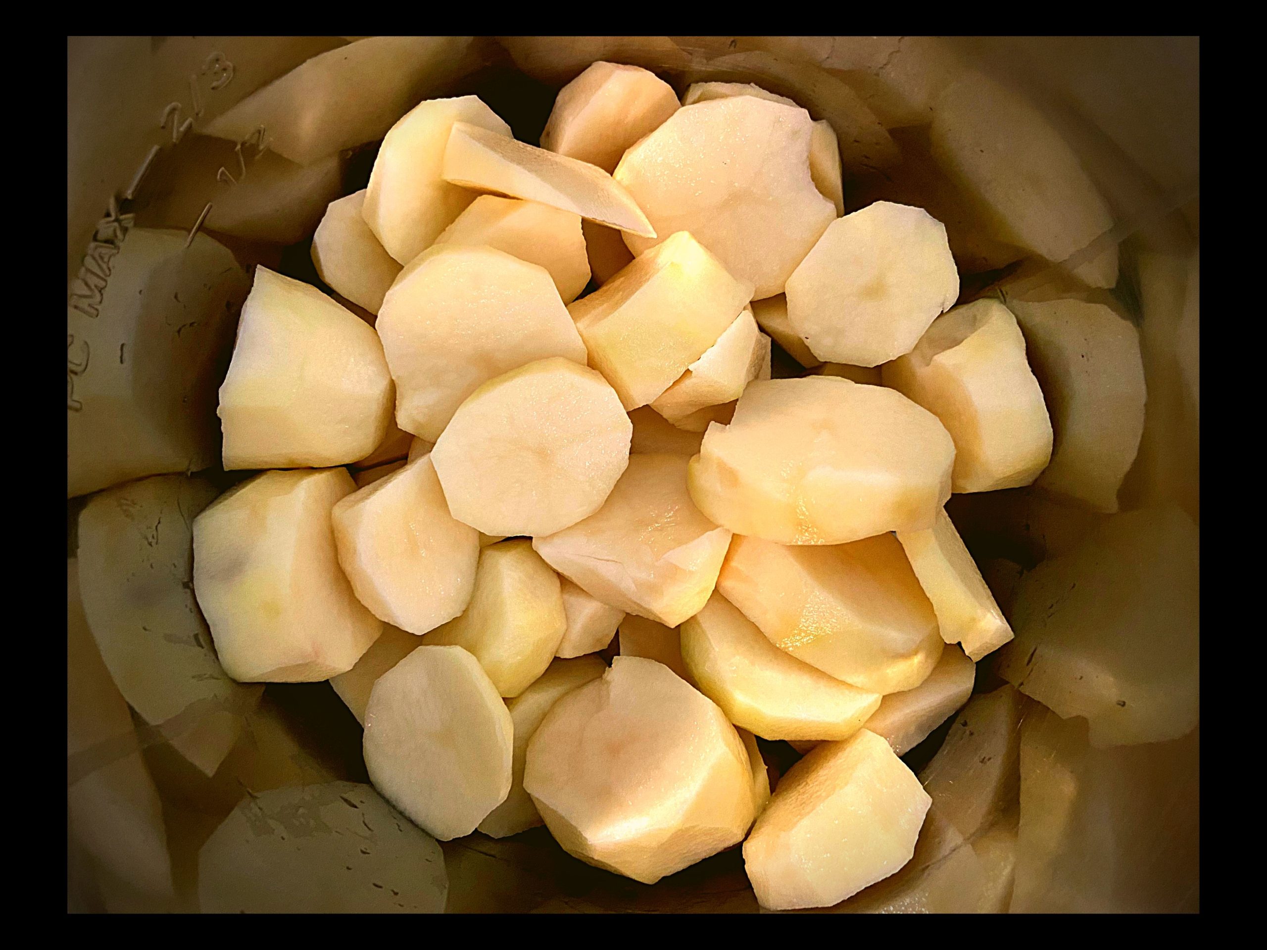 Sliced and peeled raw potatoes inside of an Instant Pot Pressure cooker