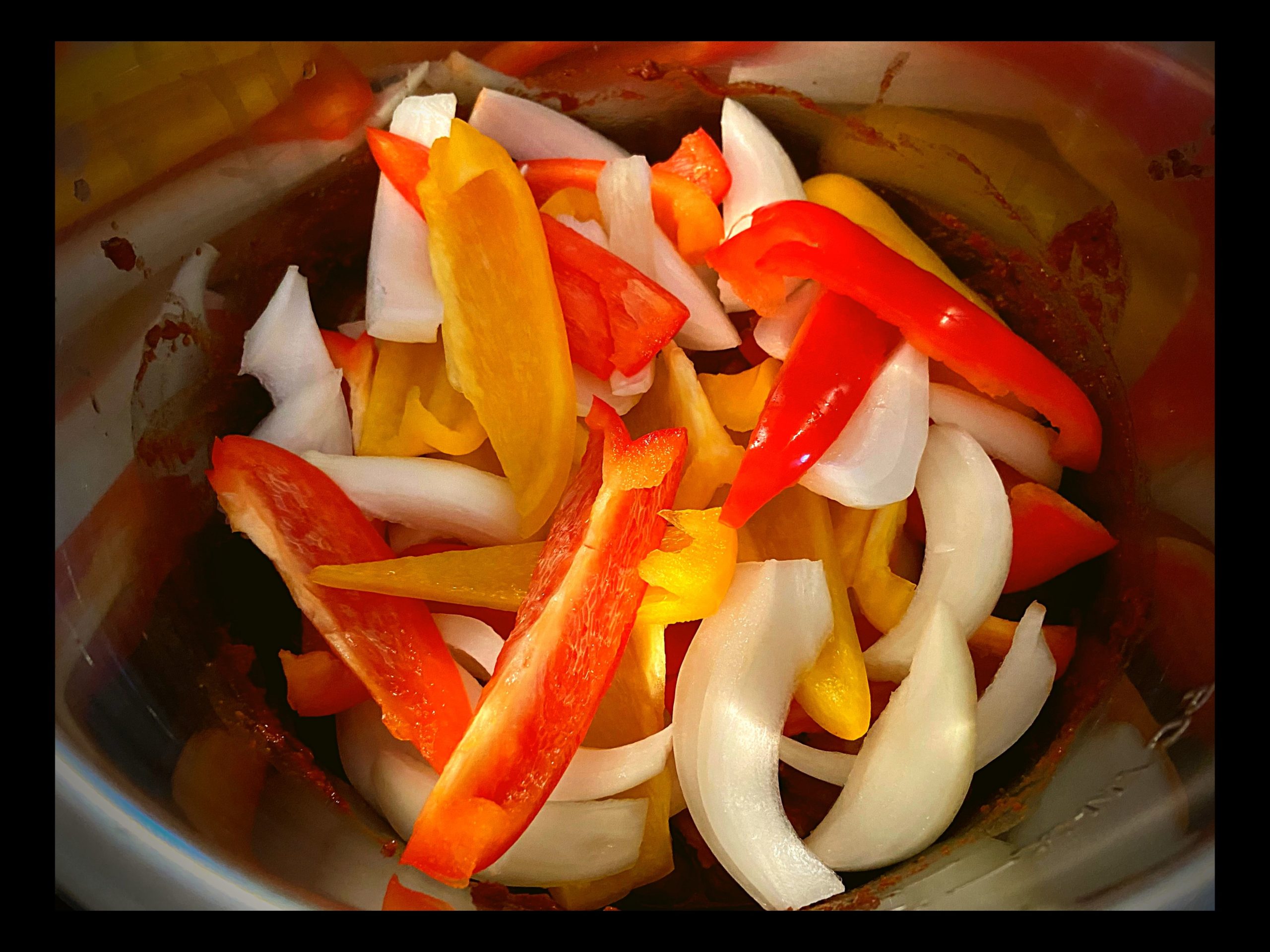 The inside of a Instant Pot filled with raw large shrimp and a packet of frontera taco sauce dump on top