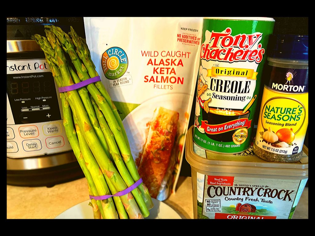 A Instant Pot, Butter, Nature Seasoning, Tony Chachere's, Salmon, and asparagus on a kitchen counter.