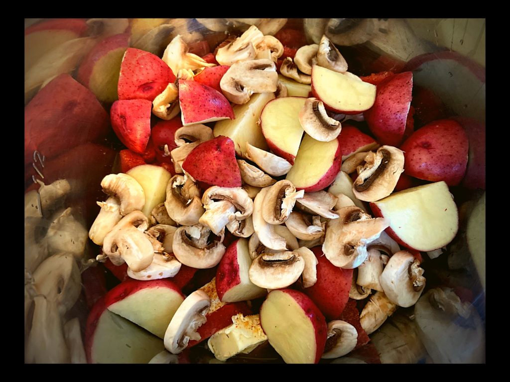 An instant pot filled with diced mushrooms and red potatotes ready to be cooked.