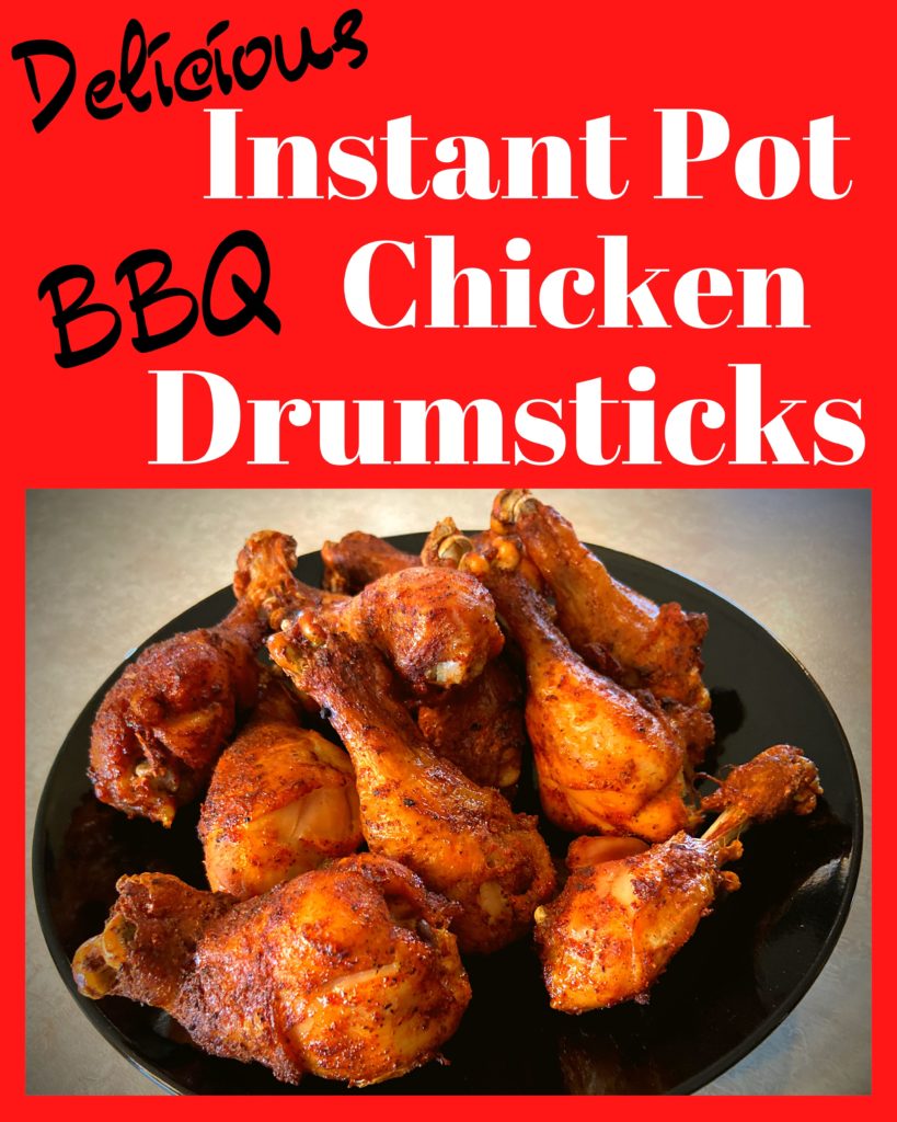 A black plate with Instant Pot BBQ Chicken Drumsticks sitting on a kitchen counter.