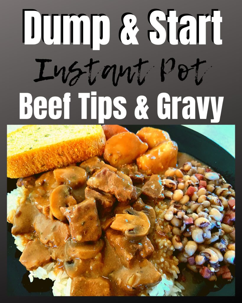 A black plate with beef tips and potatoes in a mushroom gravy over a bed of rice with black eye peas and garlic bread.