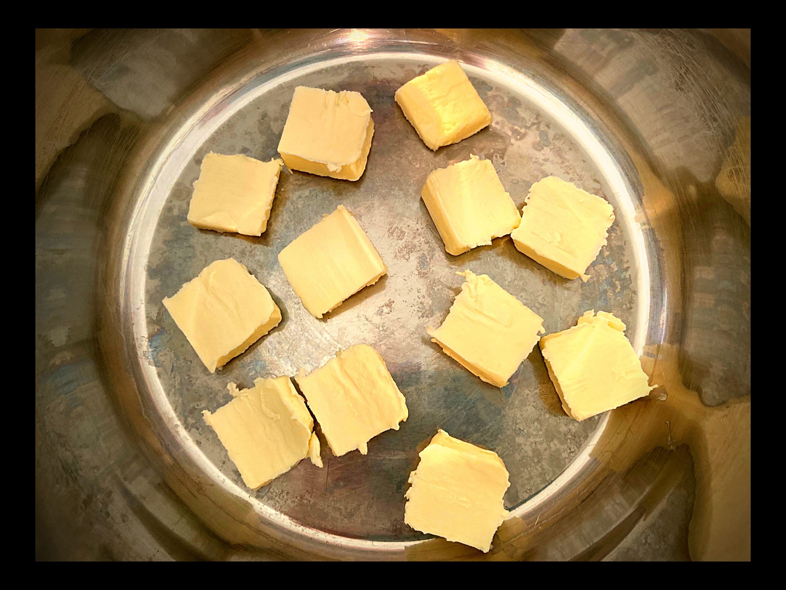 The inside of an Instant Pot with a stick of butter sliced on the bottom