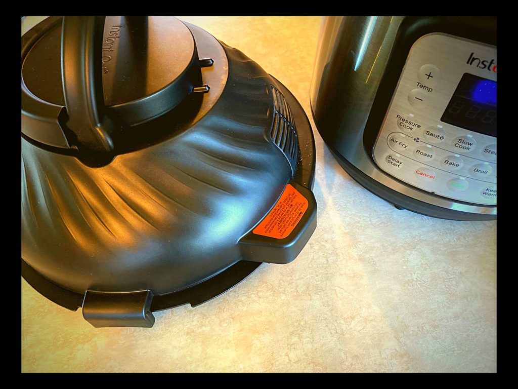 A instant pot duo crisp air fryer lid sitting next to and Instant pot on a kitchen counter top.