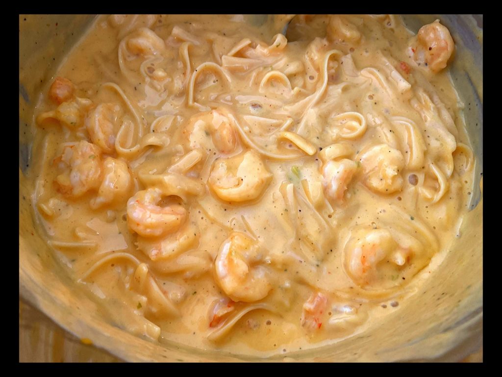 The inside of an Instant Pot filled with Cajun Shrimp Fettuccine with Velveeta cheese.