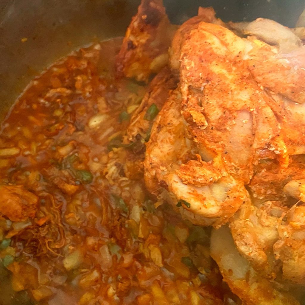 Browned onions, bell peppers, and chicken thighs in an Instant Pot.