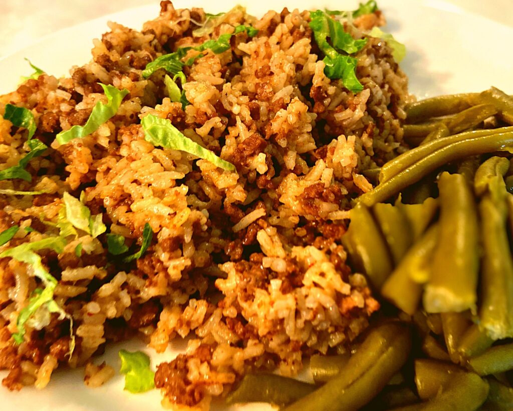 Instant Pot Ground Beef and Rice on a white plate next to green beans