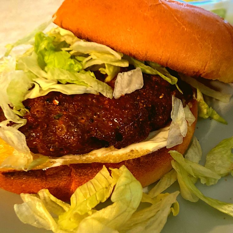 A Instant Pot BBQ Hamburger with lettuce on a grey plate.