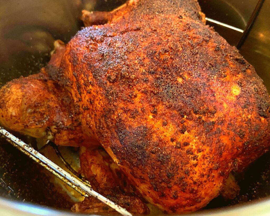 A browned chicken inside of an Instant Pot.