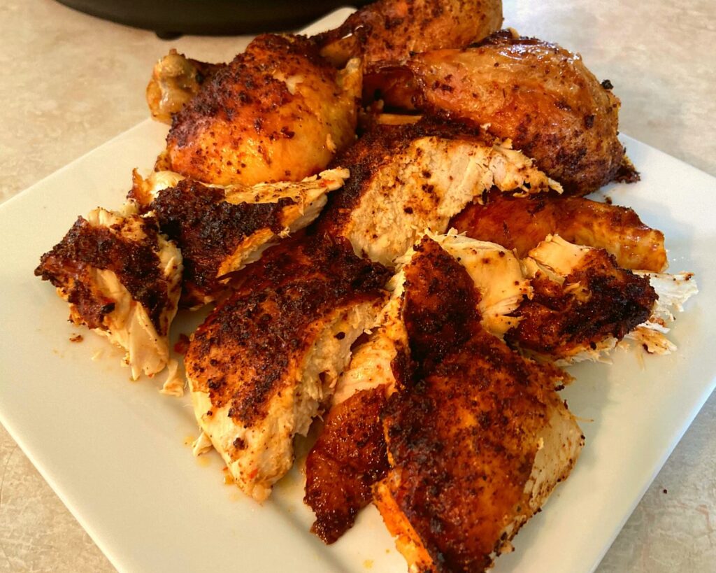 A white plate with slices of chicken and chicken legs.