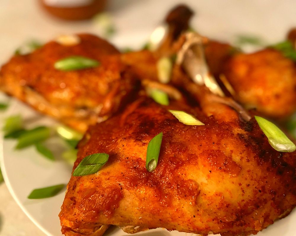 Instant Pot Chicken Leg Quarters on a white plate.