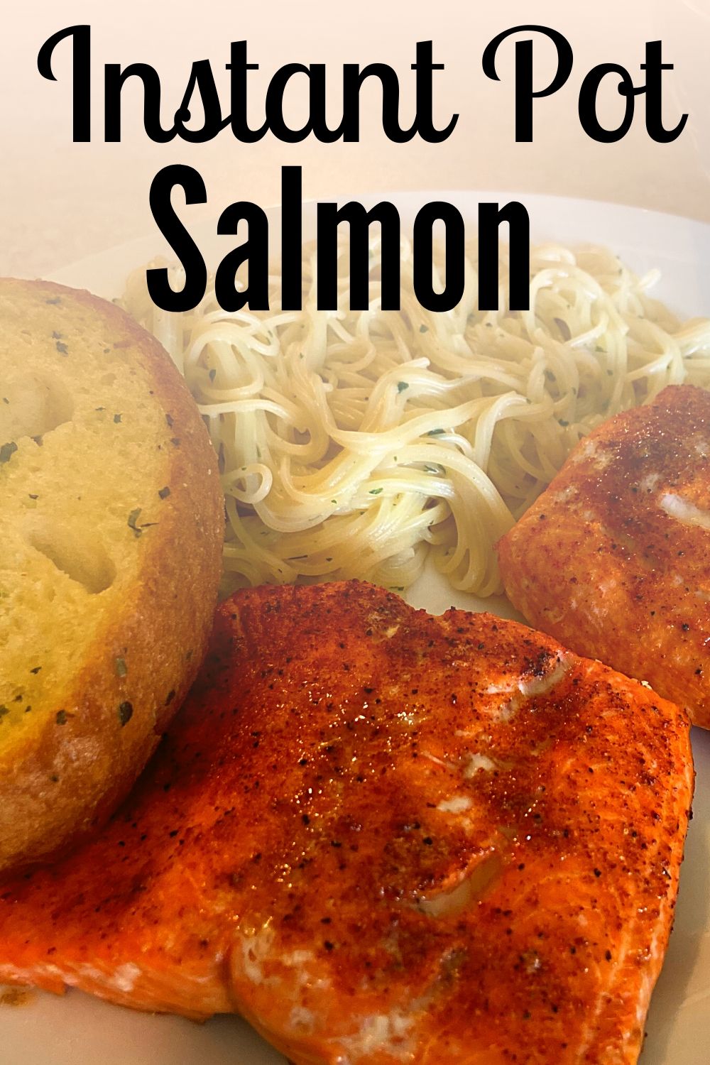 Instant Pot Salmon, angel hair pasta, and garlic toast on a white plate.