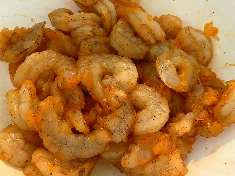 Raw shrimp covered in seasoning.