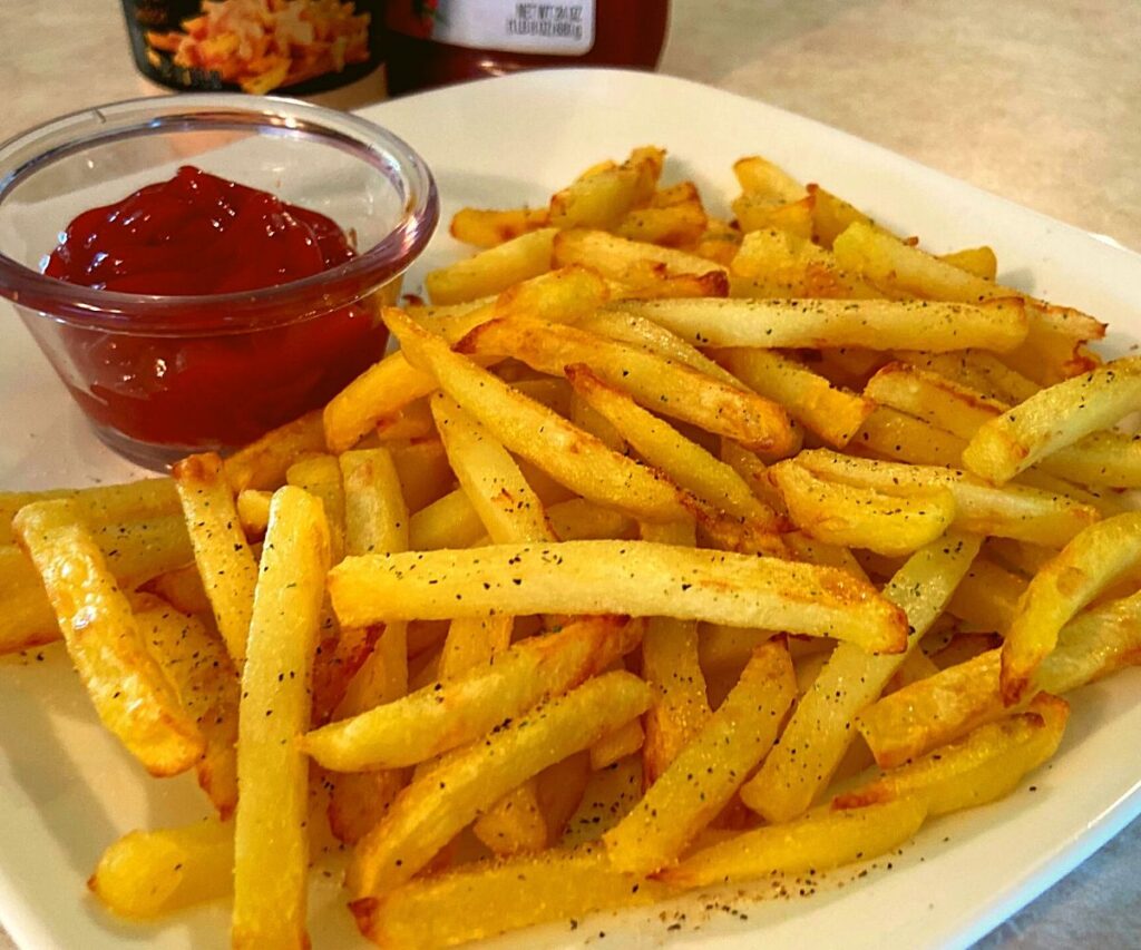 Instant Pot French Fries on a white plate with ketchup.