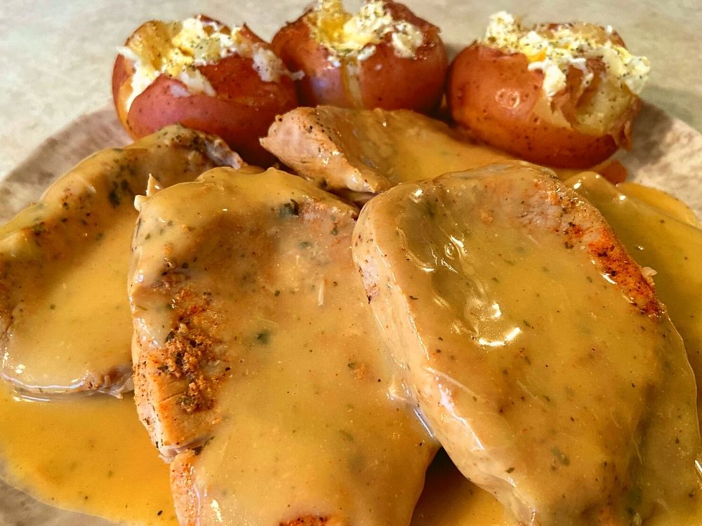 Instant Pot Ranch Pork Chops and Potatoes on a plate covered in gravy.