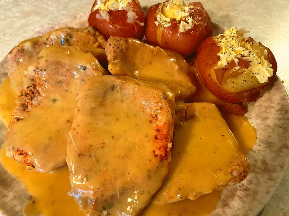 Instant Pot Ranch Pork Chops and Potatoes on a plate sitting on a kitchen counter.