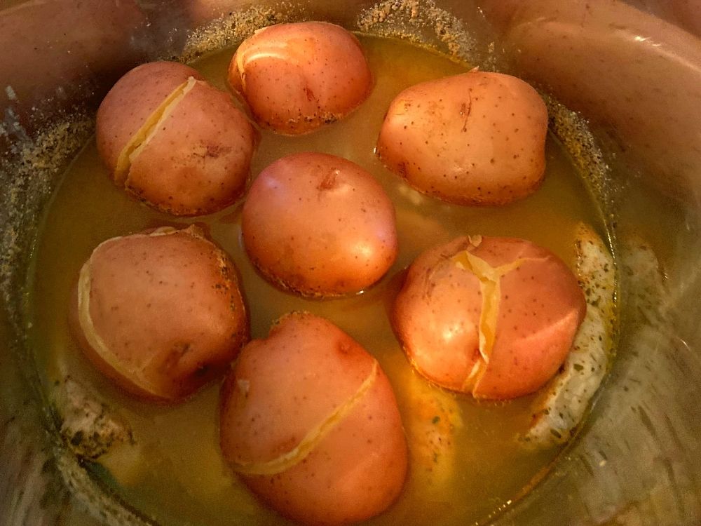 The inside of a Instant Pot filled with cooked pork chops, red potatoes, in a ranch gravy.