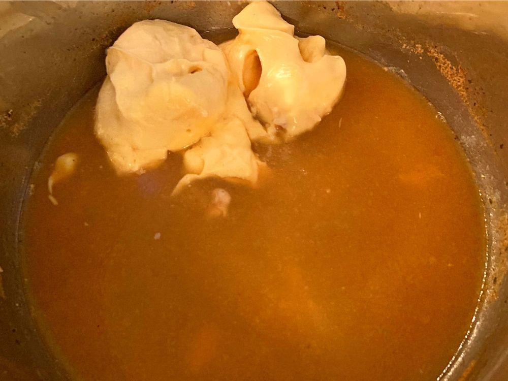 The inside of an Instant Pot filled with pork chop, ranch gravy, and a can of cream of chicken soup.