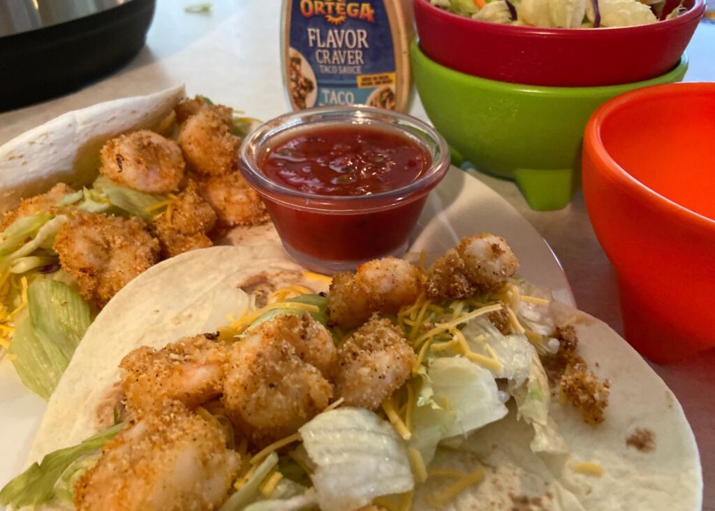 Instant pot fried shrimp tacos on a kitchen counter next to an instant pot and salsa