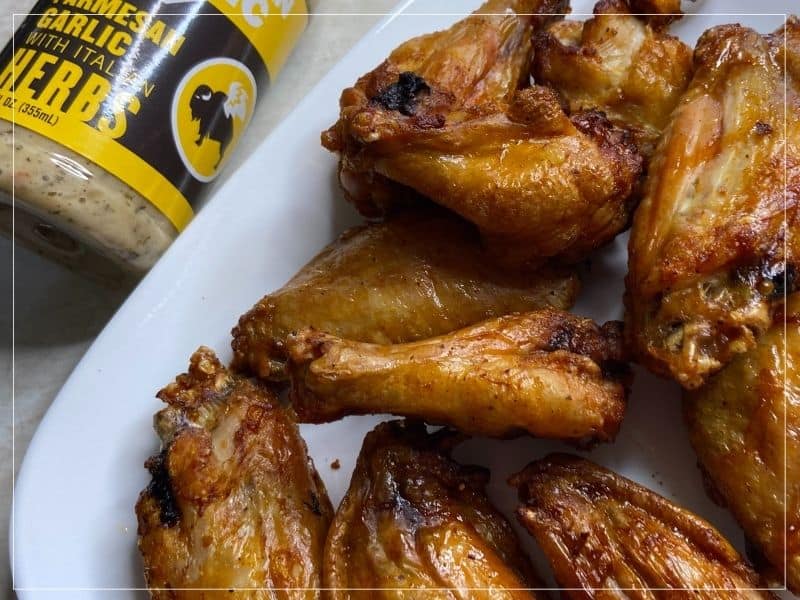 Air fryer wings with dipping sauce sitting on a plate