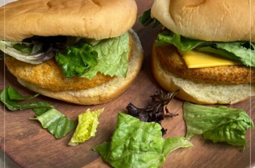 2 frozen chicken patties after being cooked in an air fryer. Sitting on a plate in hamburger buns